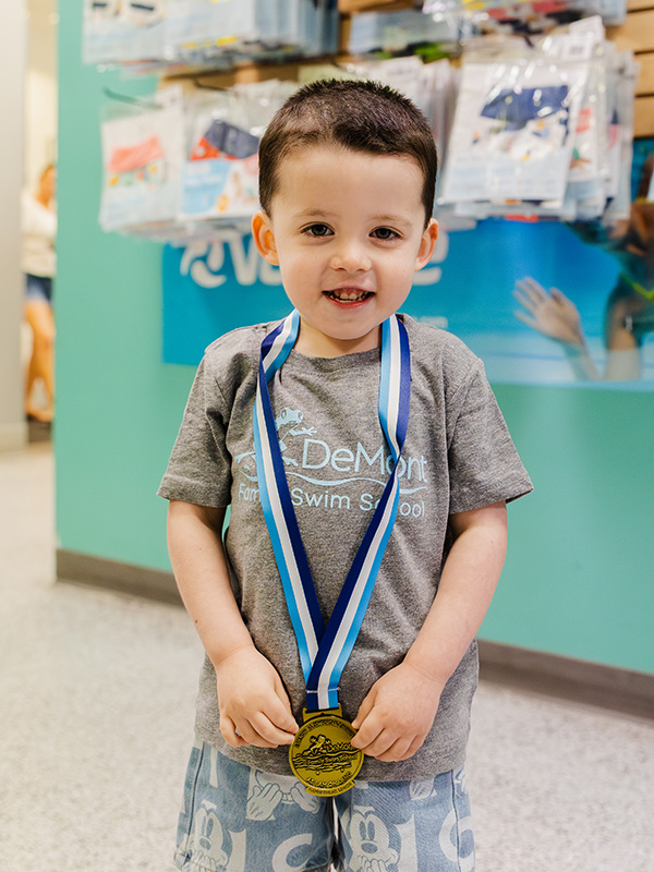 Child in DeMont Shirt wearing Gold Medal