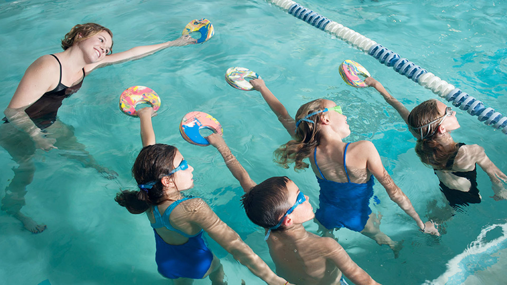 Child working on front-stroke technique with a DeMont coach
