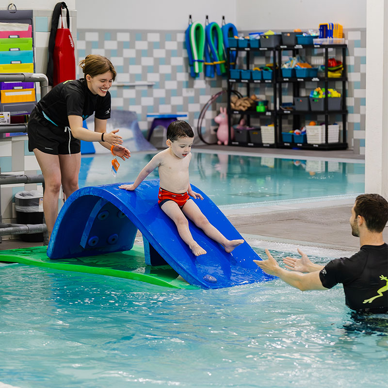DeMont Student Sliding down Slide with Instructors
